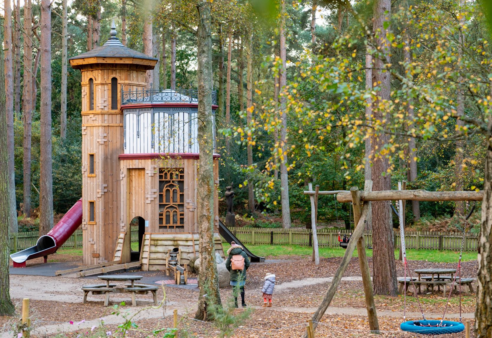 Wooden water tower structure in the woodlands as part of the pay area with a swing in the foreground