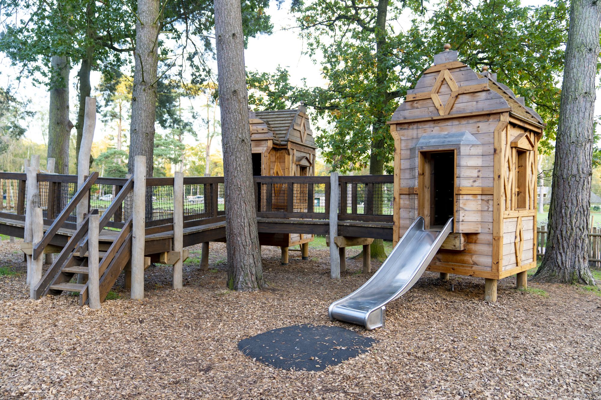 Woodland playhouse with a slide nestled in the trees